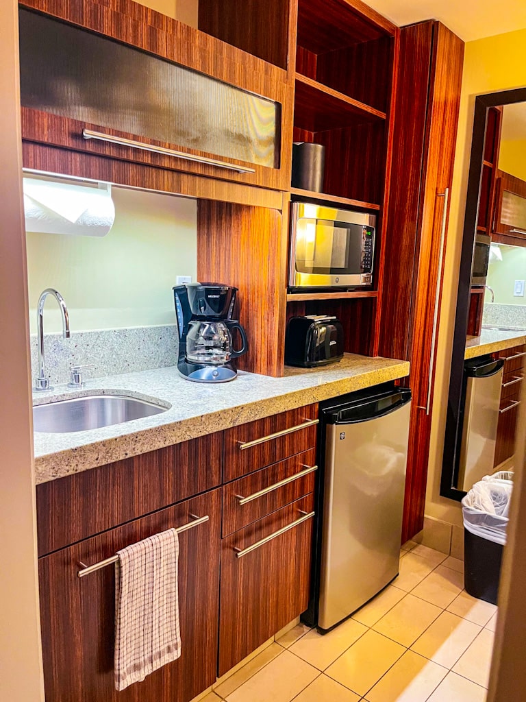 view of kitchenette with mini fridge, sink, microwave, toaster, and cofee maker