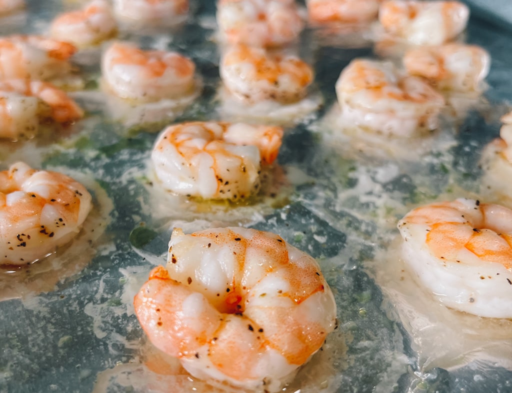 close up of roasted cooked shrimp on baking sheet