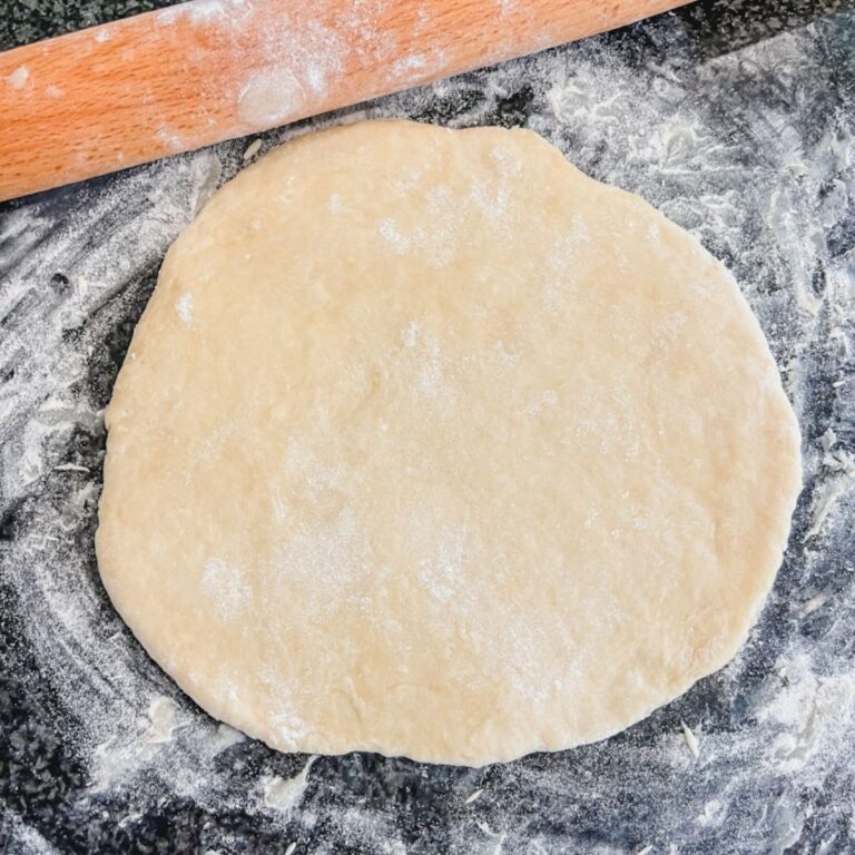 rolled out pie dough with rolling pin in background