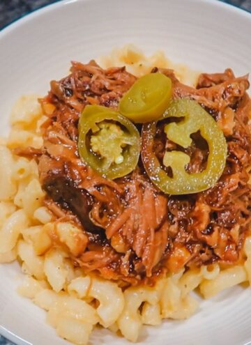 slow cooker pulled pork on top of creamy mac and cheese with jalapenos