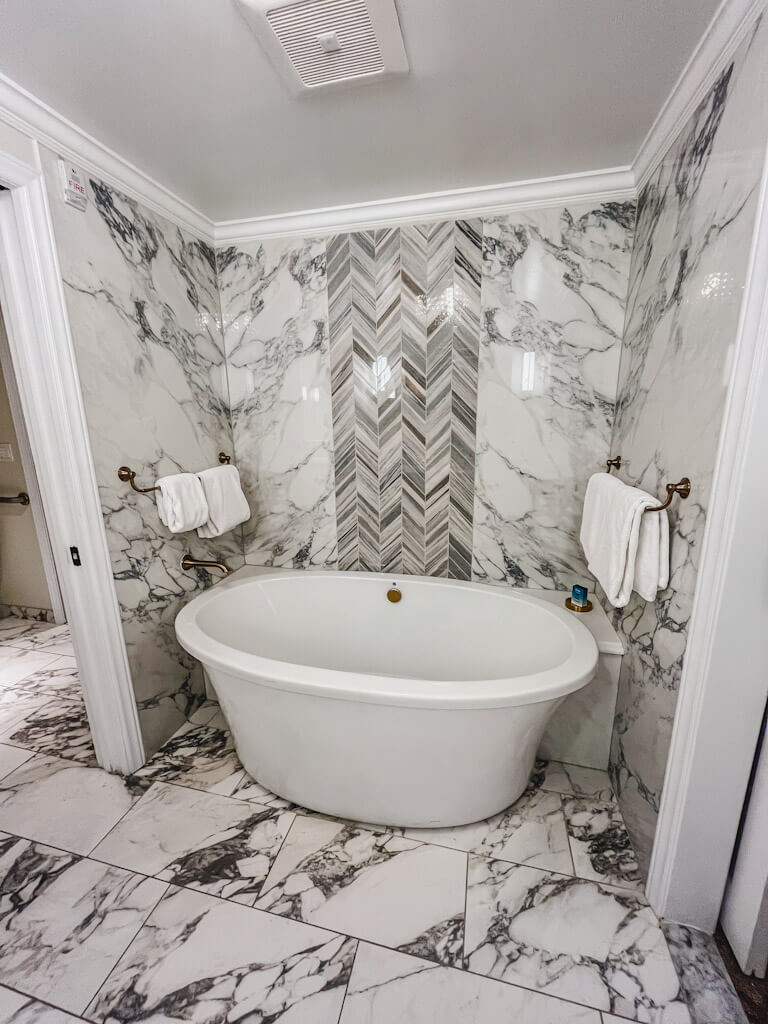 big white soaking tub amongst black and white marble designs in a one bedroom villa at Disney's Riviera Resort.