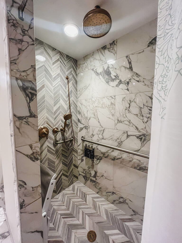 inside the large walk-in shower with rain shower head and a hand-held shower head attachment at Disney's Riviera Resort.