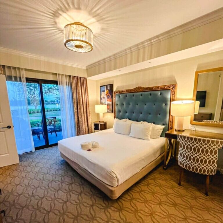 looking at king bed, desk, and patio area in a one bedroom villa at Disney's Riviera Resort.
