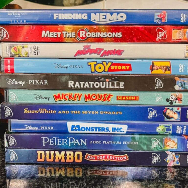 a stack of Disney movies on a black counter top.
