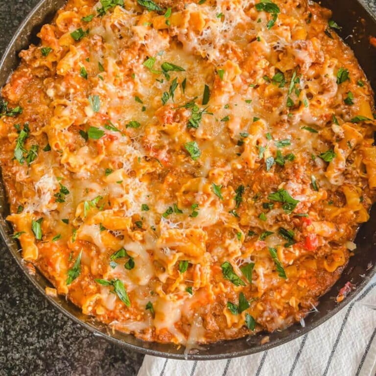 homemade one-pot lasagna casserole with a white and black towel in the foreground.