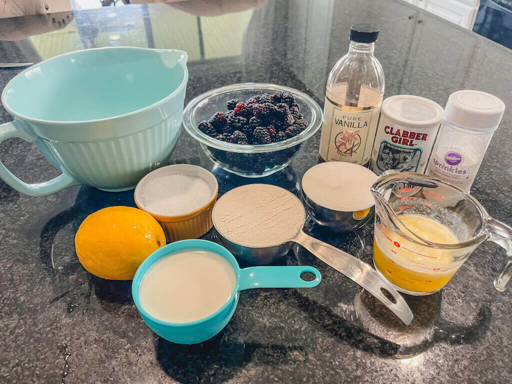 ingredients laid out on a black counter for fresh summer berry cobbler recipe.