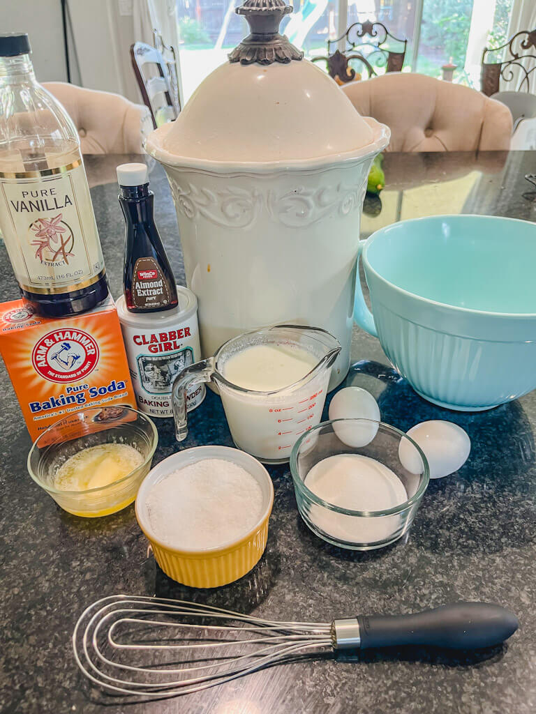 ingredients for the ultimate pancakes recipe laid out on a black countertop.