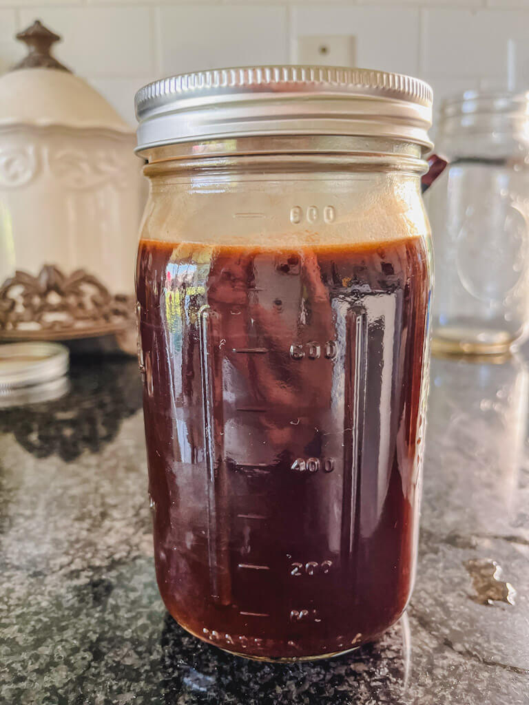 cold brew concentrate in a mason jar on a black countertop.