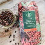 one bag of guatemala antigua starbucks whole beans coffee with loose coffee beans next to the bag.