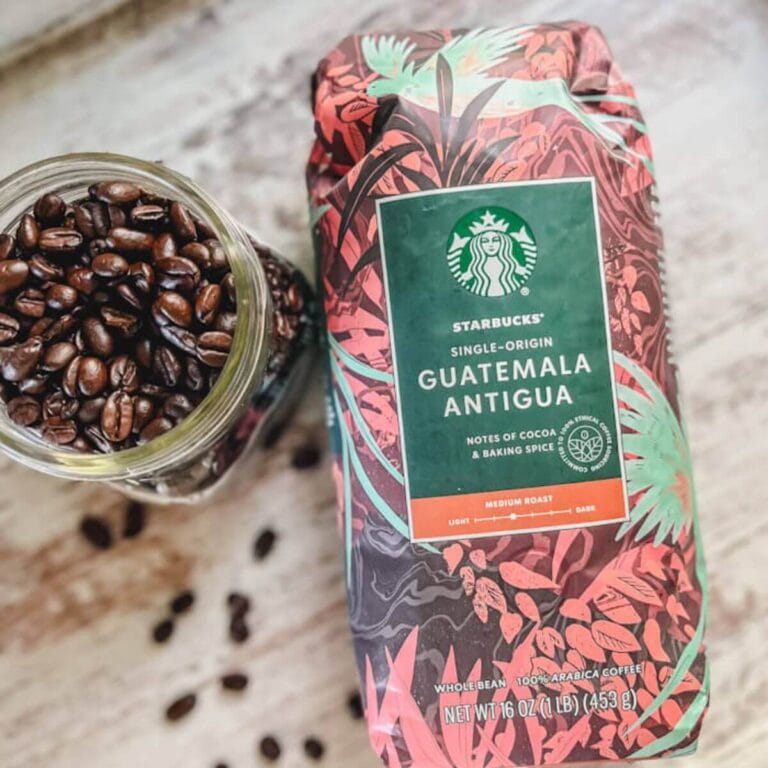 one bag of guatemala antigua starbucks whole beans coffee with loose coffee beans next to the bag.