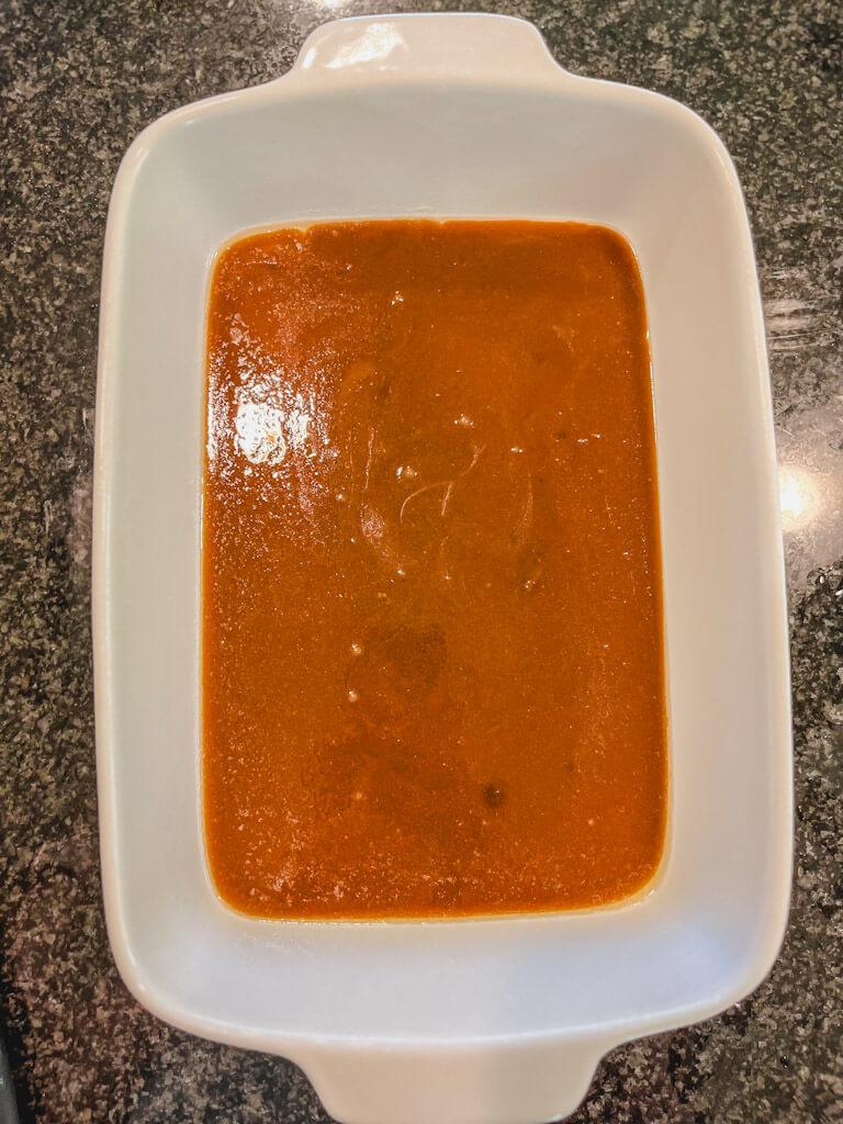 creme brulee sauce poured into a white baking dish.