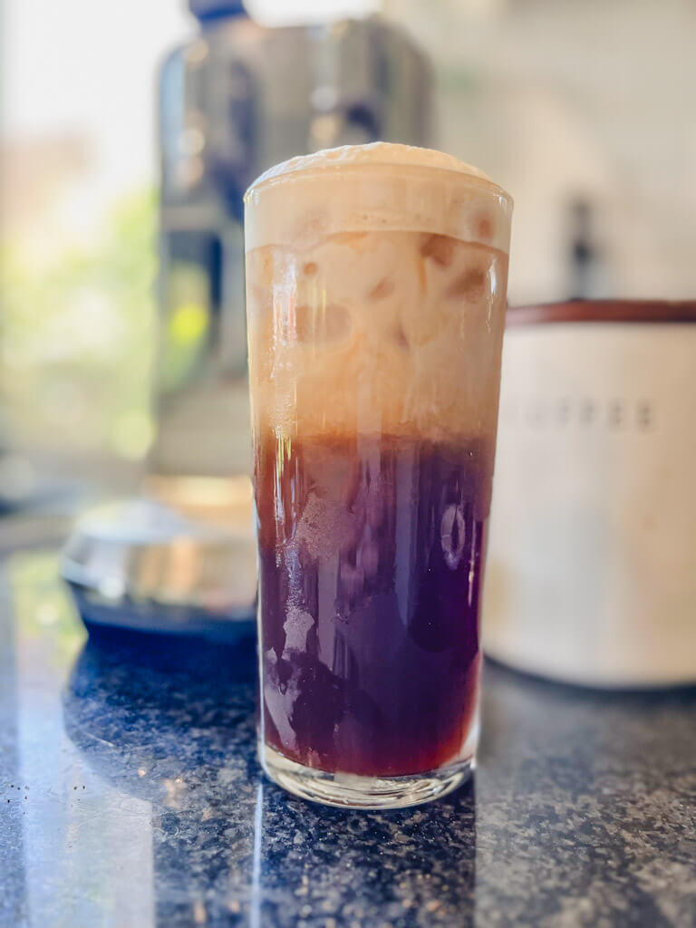far away picture of shaken espresso in a tall glass.