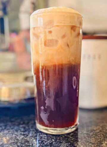 starbucks iced shaken espresso in a tall glass on a black counter.