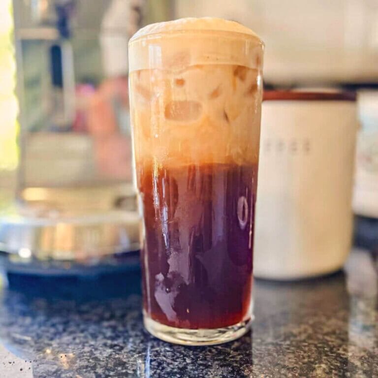 starbucks iced shaken espresso in a tall glass on a black counter.