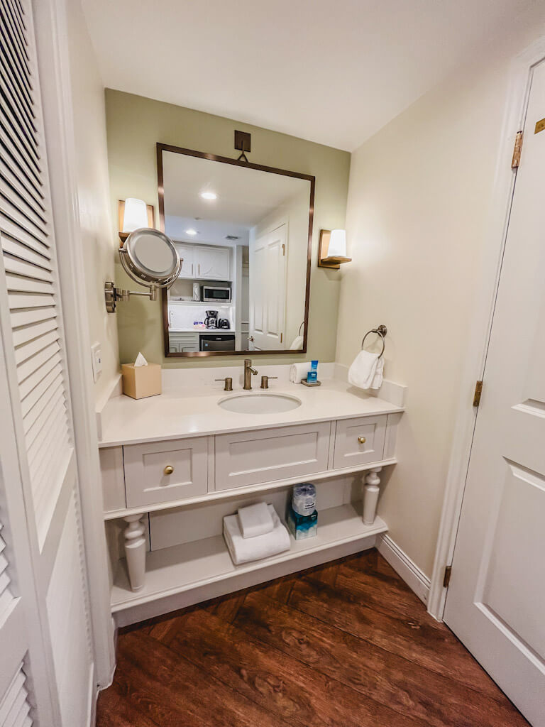 the vanity area with a large mirror, towels, and drawer space. 