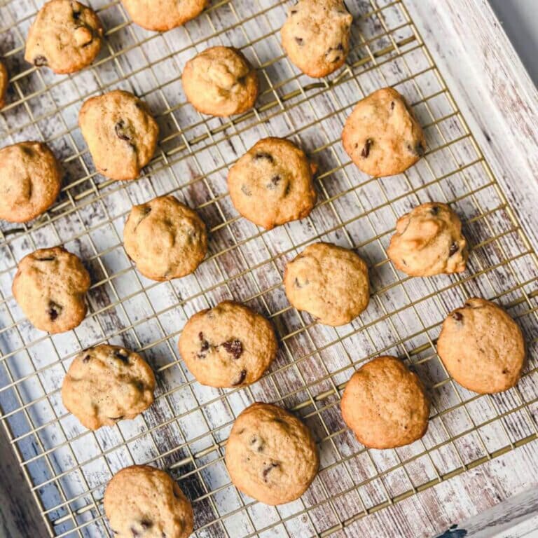 overhead view of lunchbox mini chocolate chip cookies on a cooling rack on top of a white serving board.