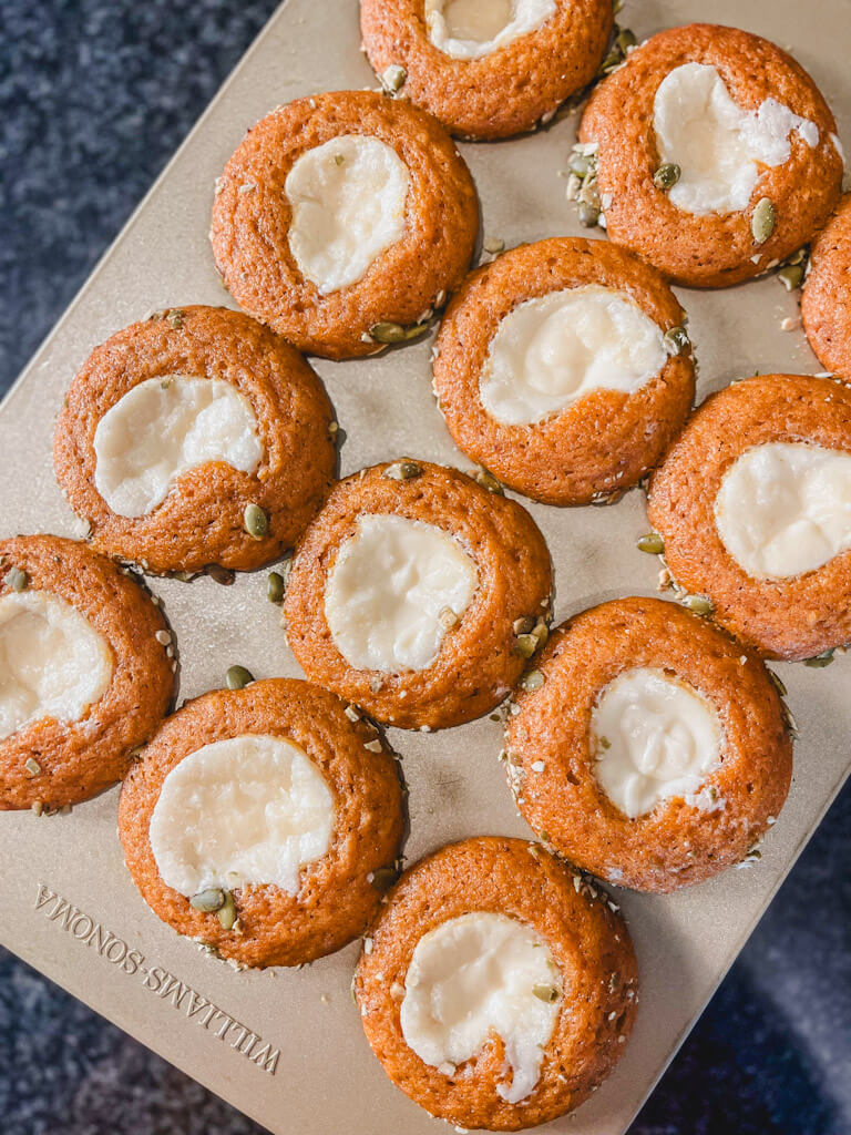 12 starbucks copycat pumpkin cream cheese muffins in a gold muffin pan.