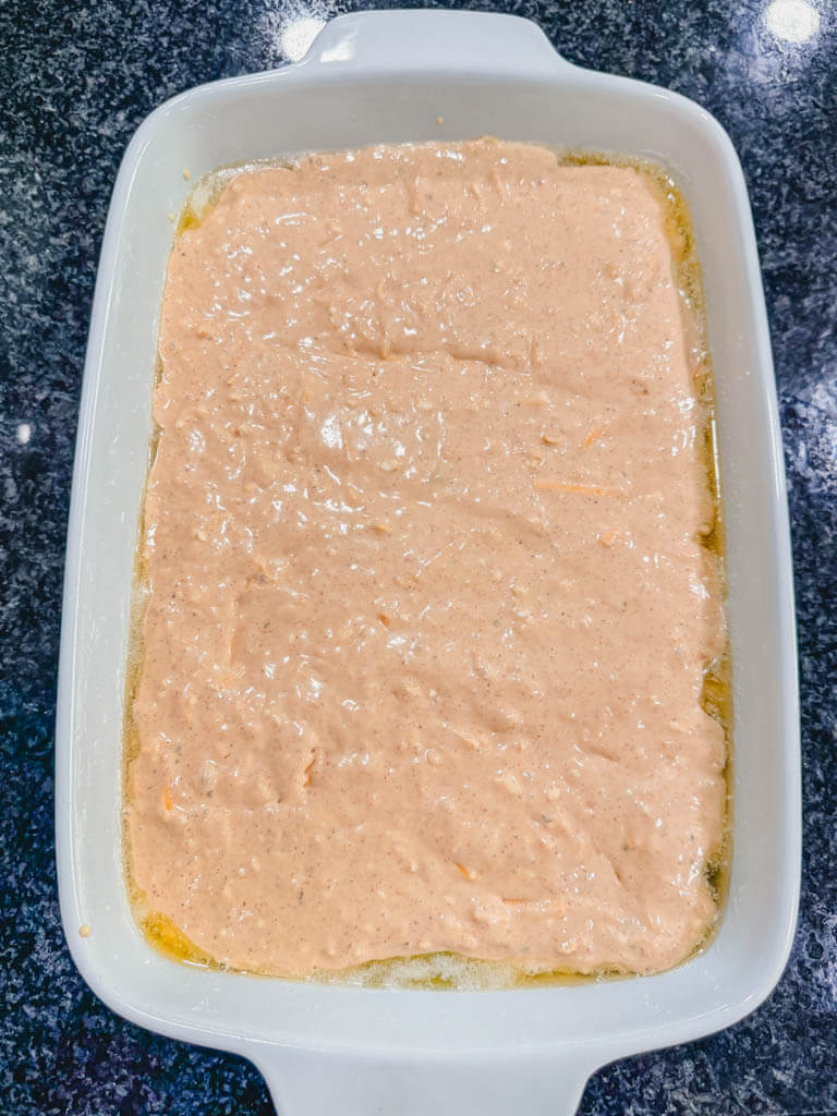 cheesy biscuit mixture added to the top of the soup and chicken mixture in the white baking casserole dish. 