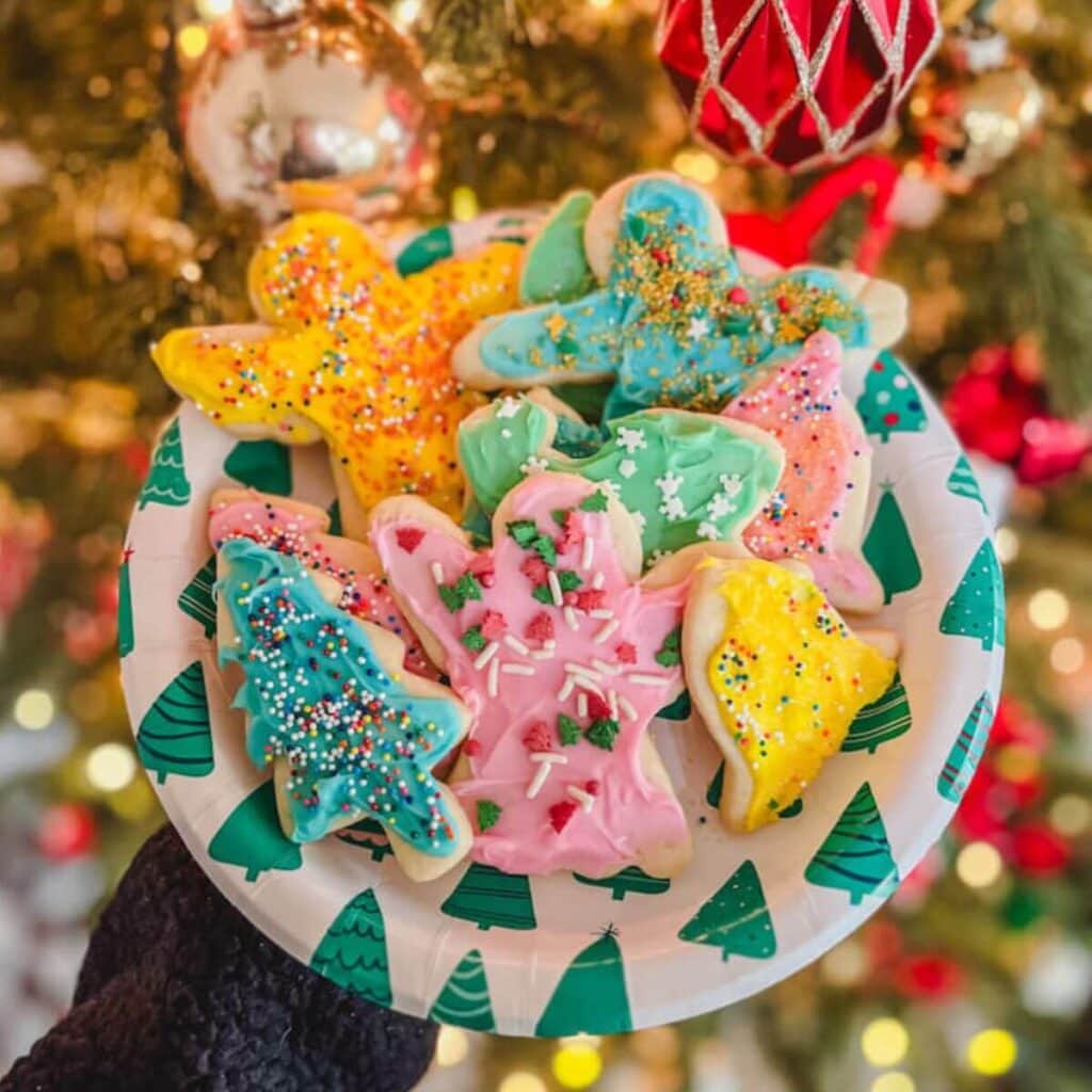 small batch Christmas sugar cookies cut out recipe on a plate in front of a Christmas tree.