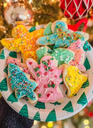 small batch Christmas sugar cookies cut out recipe on a plate in front of a Christmas tree.
