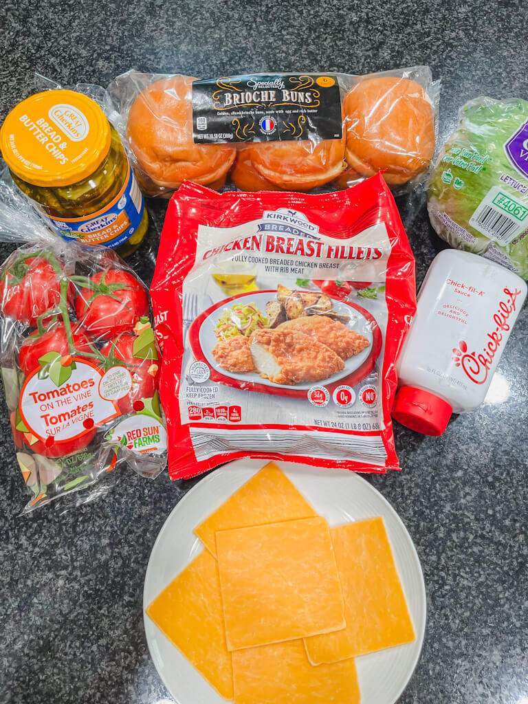 ingredients for ALDI chick-fil-a sandwich made in the air fryer laid out on a black counter.