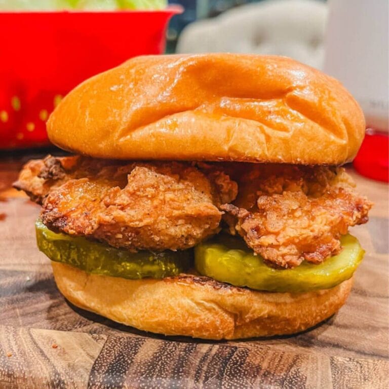 close up of aldi copycat chick-fil-a chicken sandwich on a wooden cutting board.