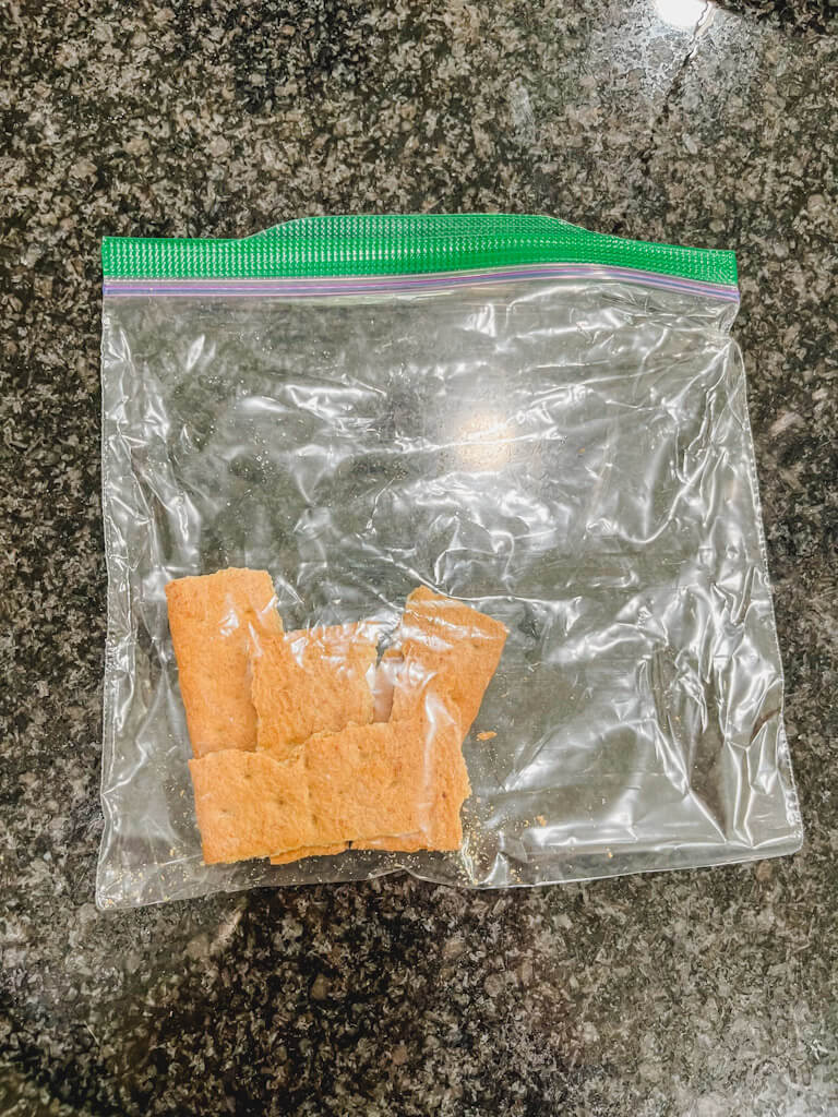 a graham cracker in a plastic bag about to smashed into crumbs.