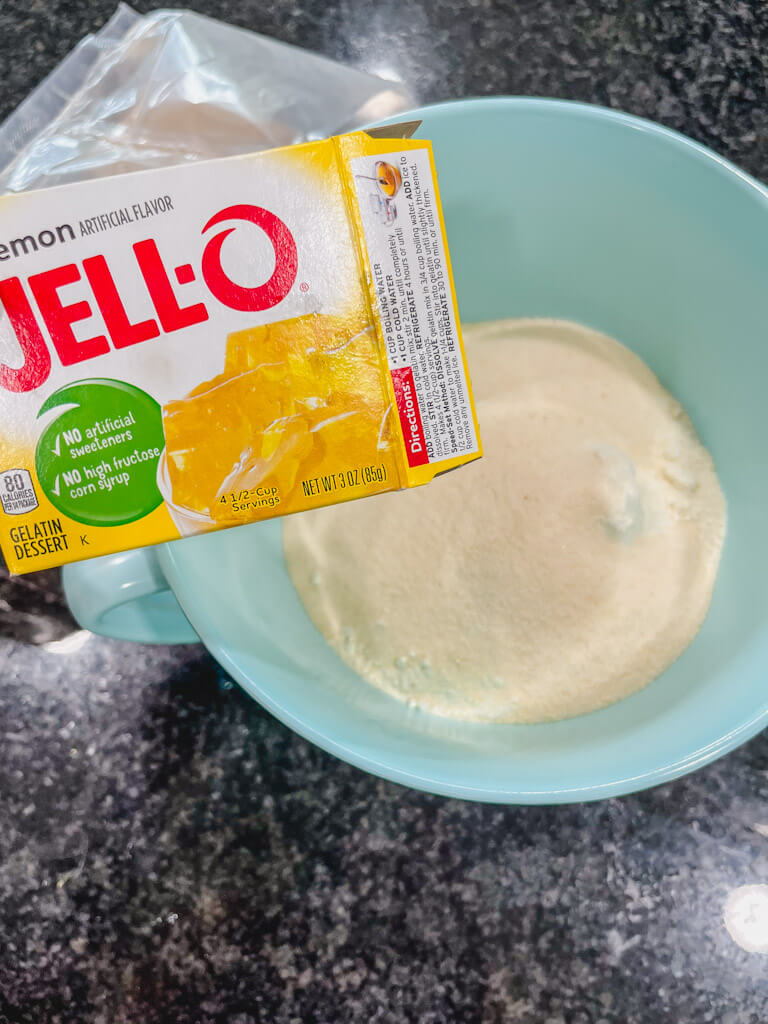 a box of lemon jello about to be added to the mixing bowl.