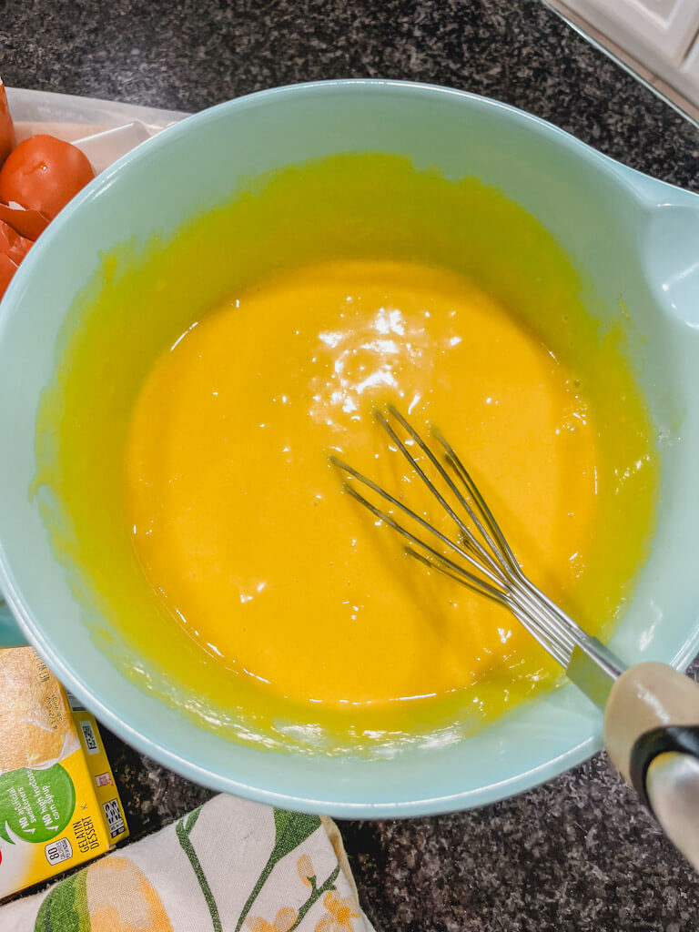 old fashioned jello lemon cake batter after being whisked together in a blue mixing bowl.