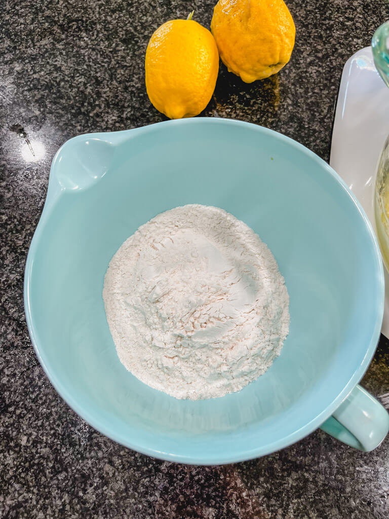 white all purpose flour added to a separate blue mixing bowl.