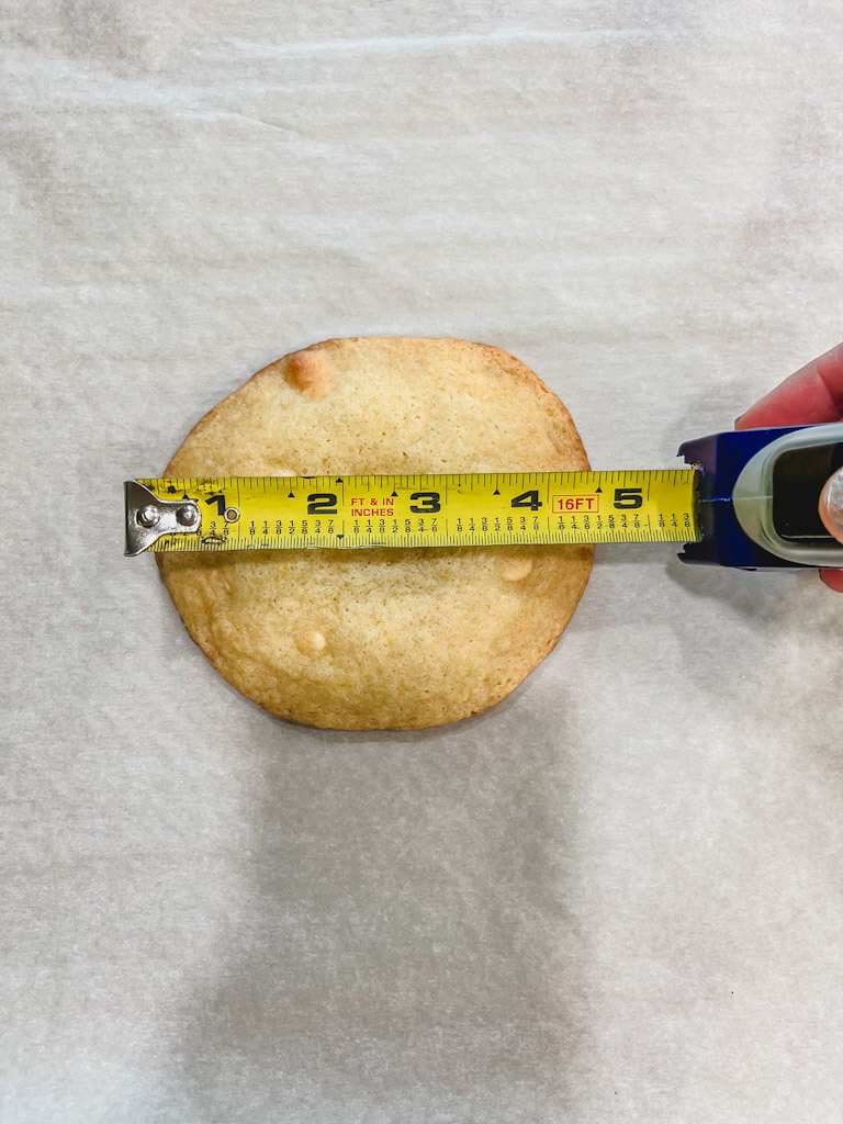 measuring tape held out to 5 inches showing how large the lemon drop cookie is.