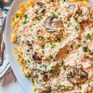 close up of 5-ingredient slow cooker creamy chicken on a white serving platter ready to eat.