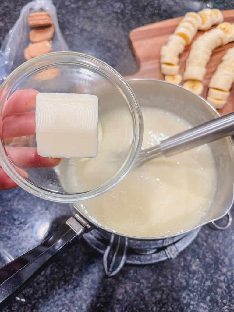 butter in a glass measuring dish about to be added to the pudding mixture in the saucepan.