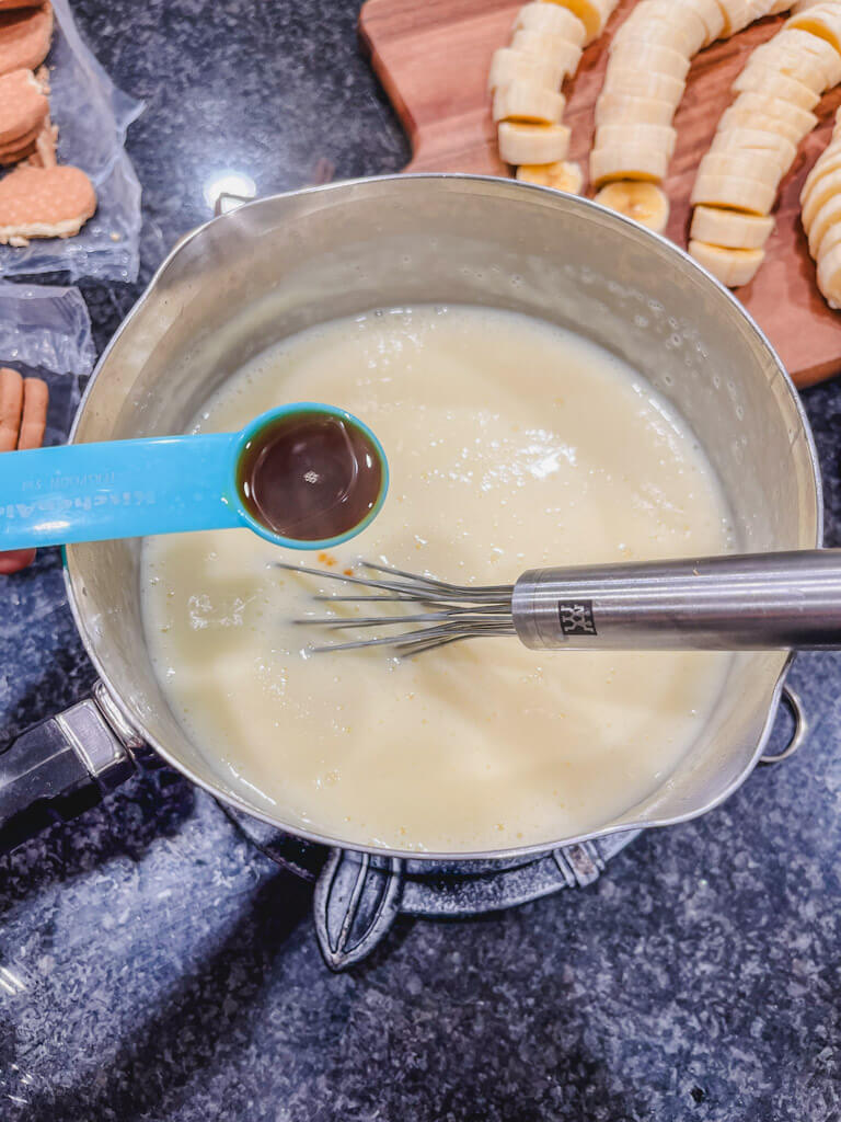 a teaspoon of vanilla extract about to be added to the pudding.