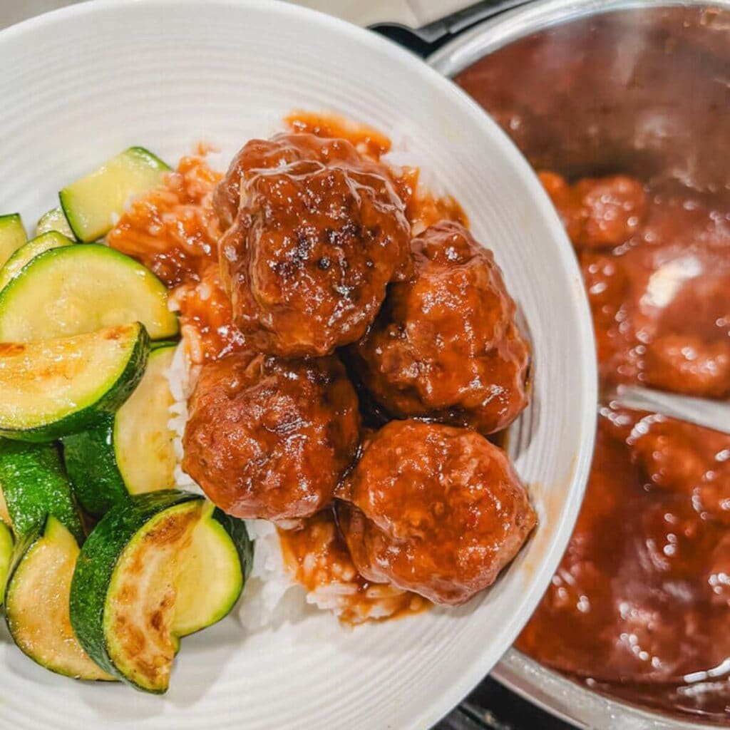 instant pot sweet and sour meatballs served over white rice in a white bowl.