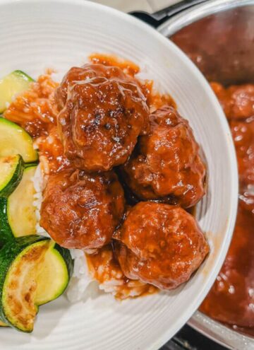 instant pot sweet and sour meatballs served over white rice in a white bowl.