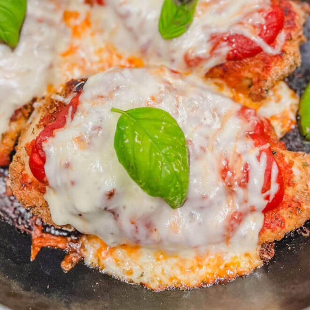 close up of one pan chicken parmesan in a cast iron skillet.