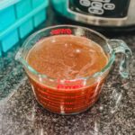overhead view of crockpot chicken bone broth in a a large glass dish.