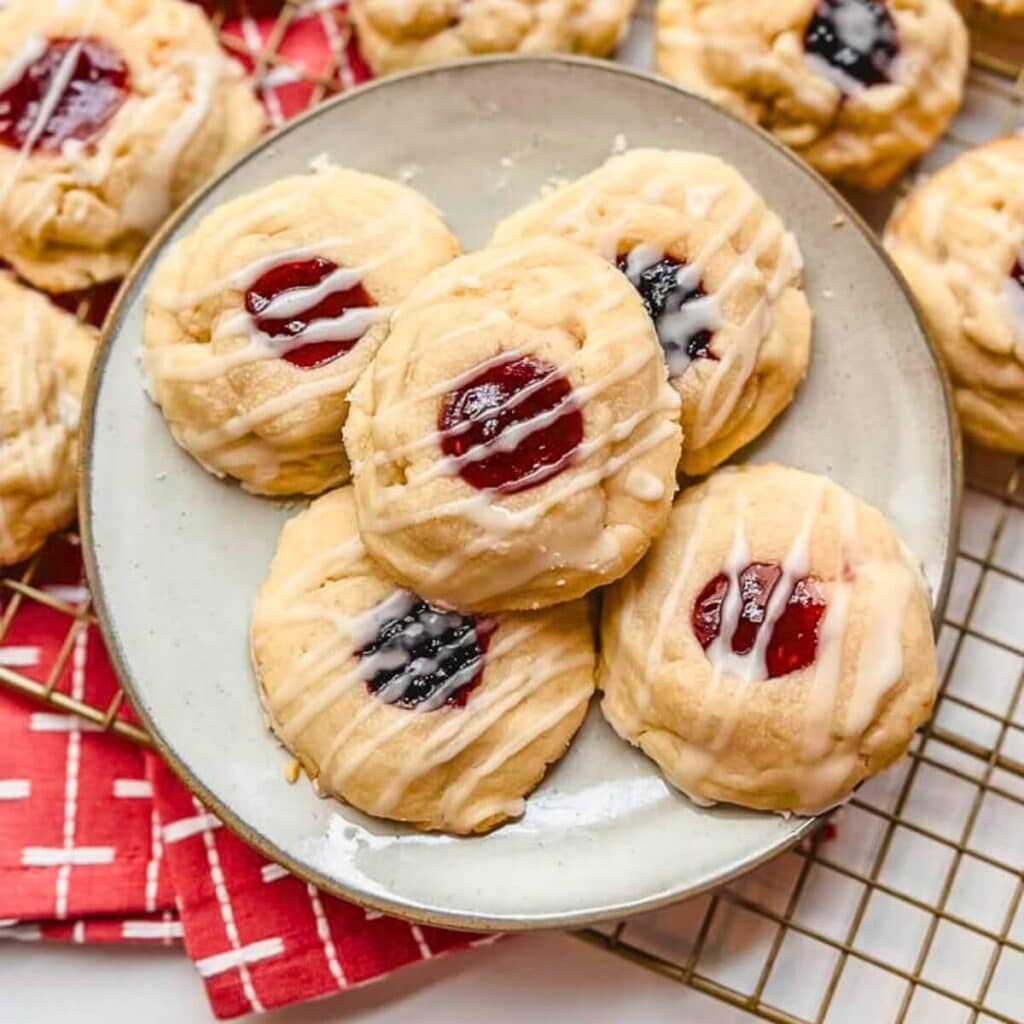 overhead view of thumbprint cookies on a white plate.