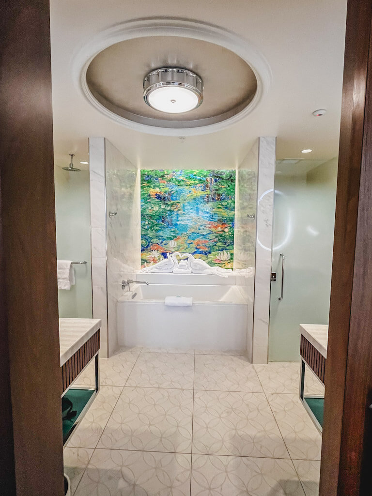 master bathroom soaking tub with swan towels in the center.