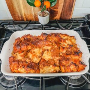 overhead picture of overnight French toast casserole in a white baking dish resting on the stove.