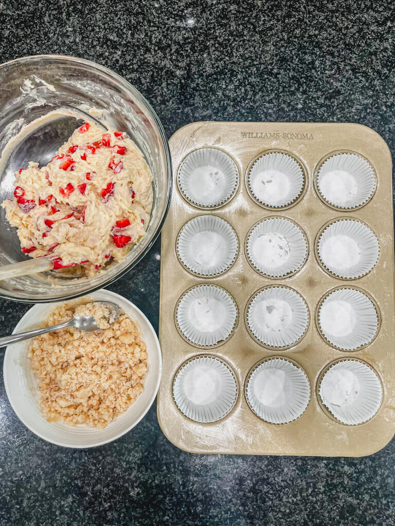 overhead view of prepared muffin tin next to the muffin batter and streusel crumble.
