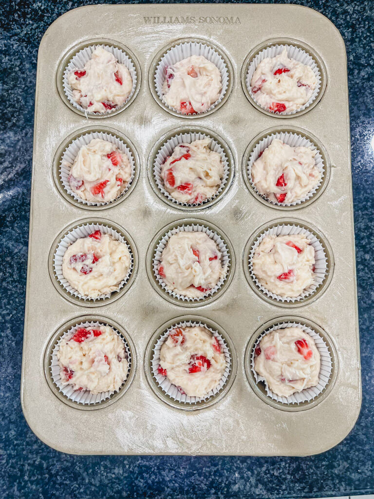 muffin tin with the strawberry muffin batter added 3/4 of the way full.