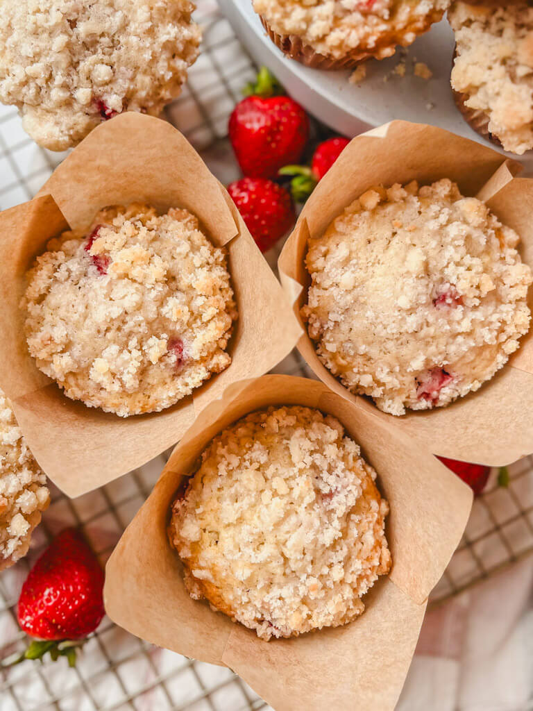 close up of strawberry streusel muffins surrounded by fresh strawberries.