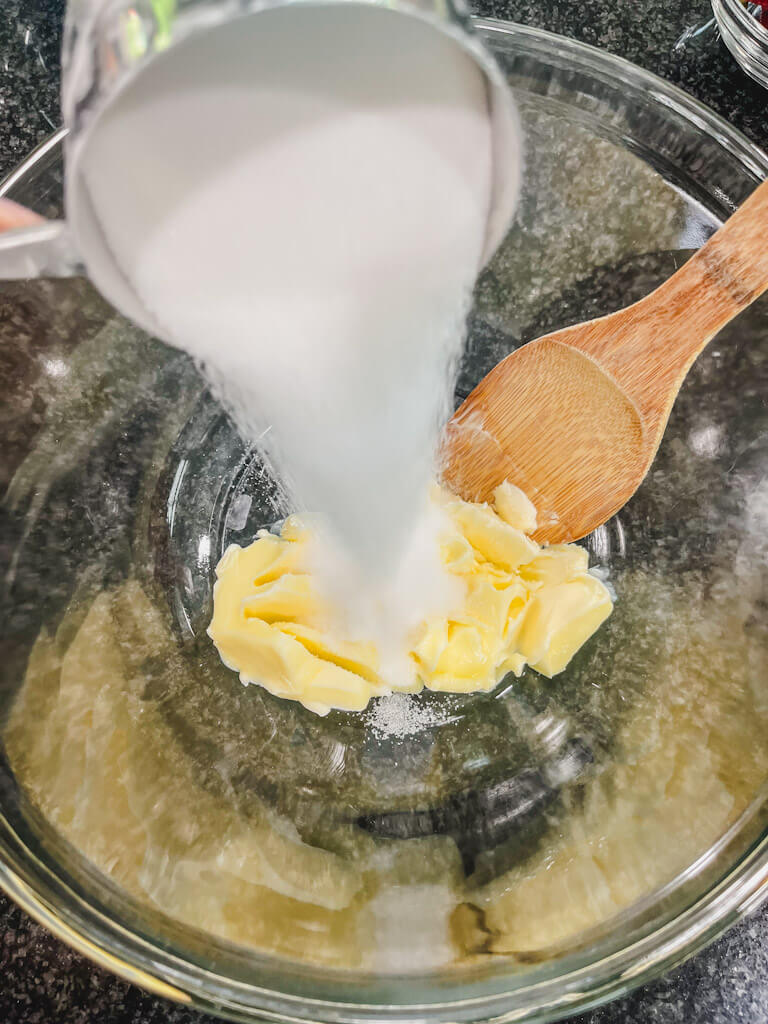 softened butter and sugar being added to a bowl for strawberry streusel muffins.