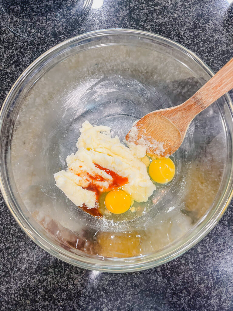 two eggs, vanilla extract, and almond extract added to the butter and sugar mixture.