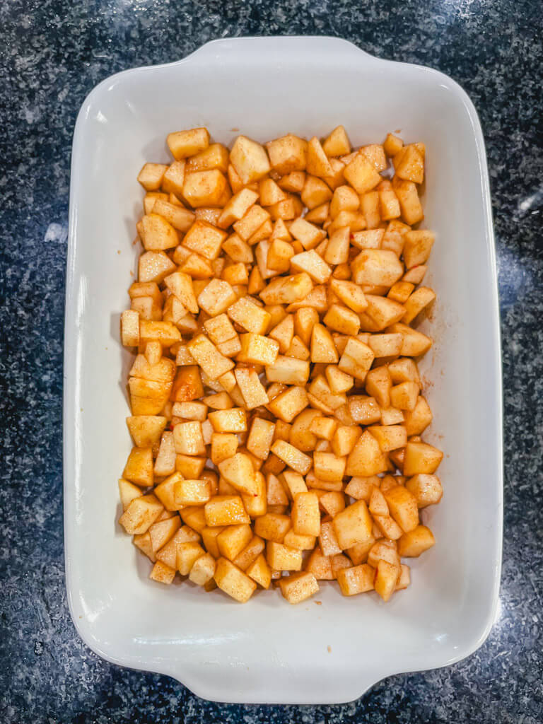 apples in the prepared baking dish waiting for the oat crumble on top.
