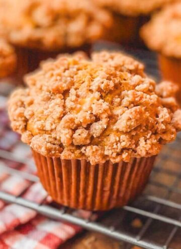 close up picture of a pumpkin apple streusel muffin on a wire rack.