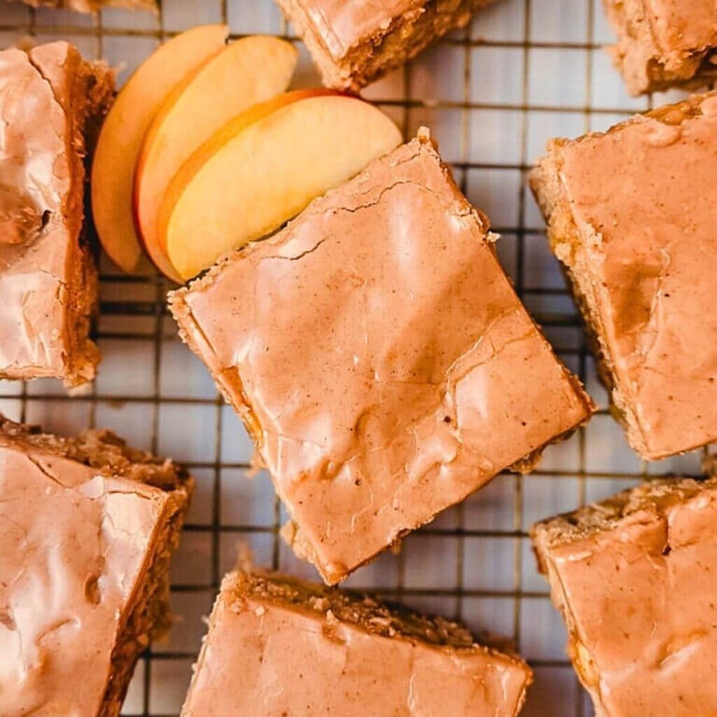 overhead view of sliced apple blondies on a wire rack next to some sliced apples.