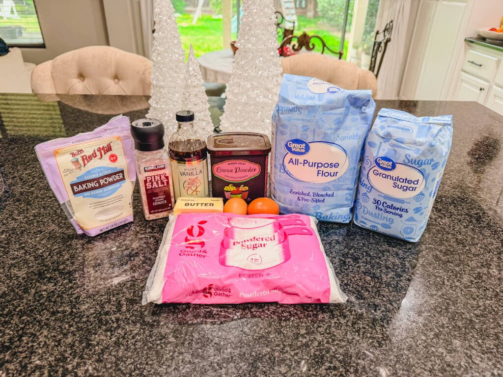 ingredients laid out on a black counter top for chocolate crinkle cookies.
